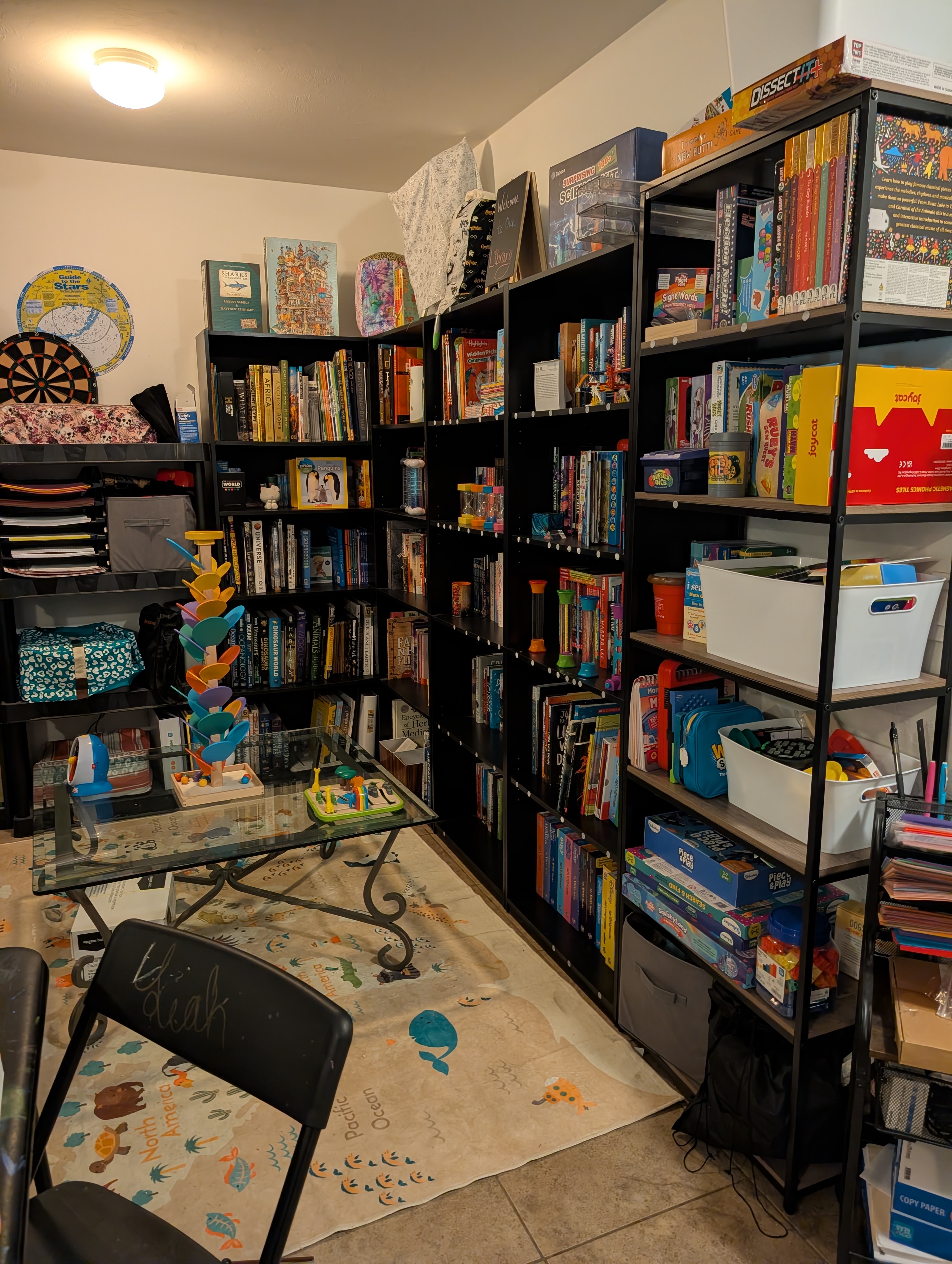 Our home classroom shelves, packed with well-loved books and board games